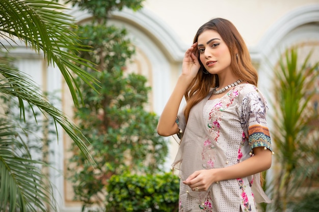 Confiante linda garota paisagem no jardim usando vestido Desi para sessão de fotos de moda