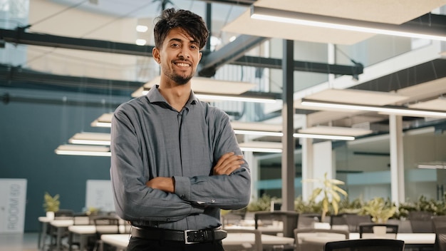 Confiante sorridente homem de negócios indiano empregado financeiro masculino trabalhador profissional fica no escritório