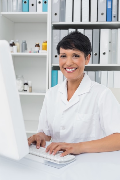 Foto confiante sorrindo doutora usando computador