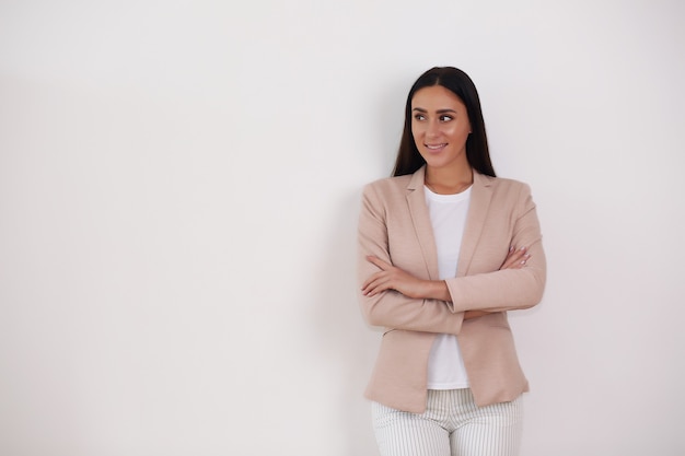 Confianza empresaria elegante joven sonriente en traje de ropa mirando a cámara aislada sobre fondo gris de estudio,