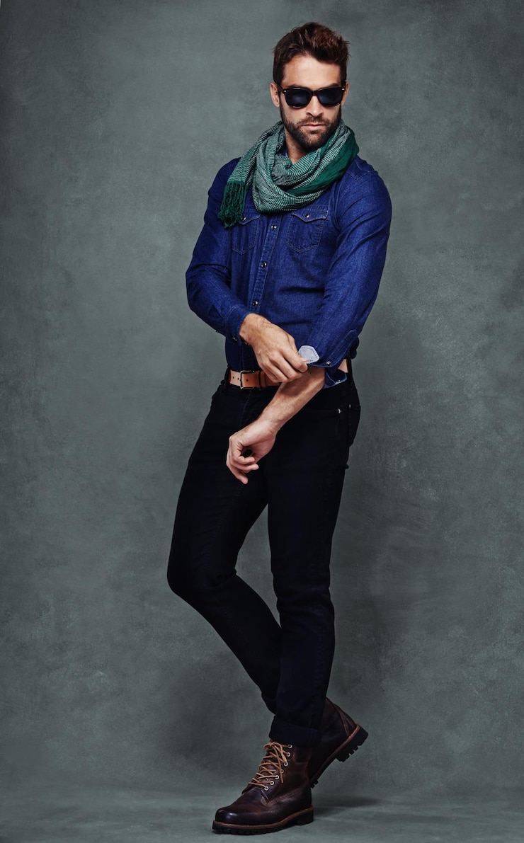 Foto confianza en la moda y hombre o modelo en el estudio aislado en un fondo gris espacio de maqueta persona seria y manga enrollada en camisa para el estilo en ropa casual gafas de sol de moda o frescas con vaqueros