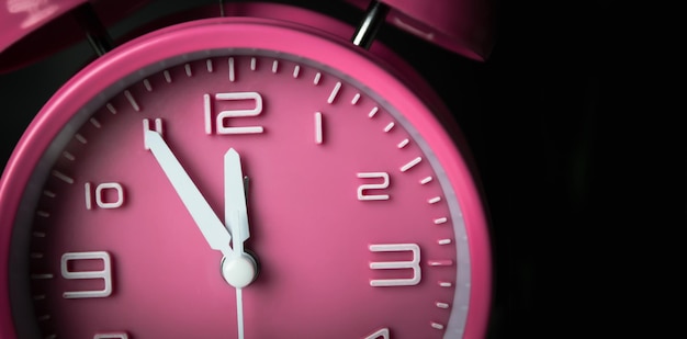 Configuração de despertador rosa às cinco antes do meio-dia ou meia-noite Tempo conceitual