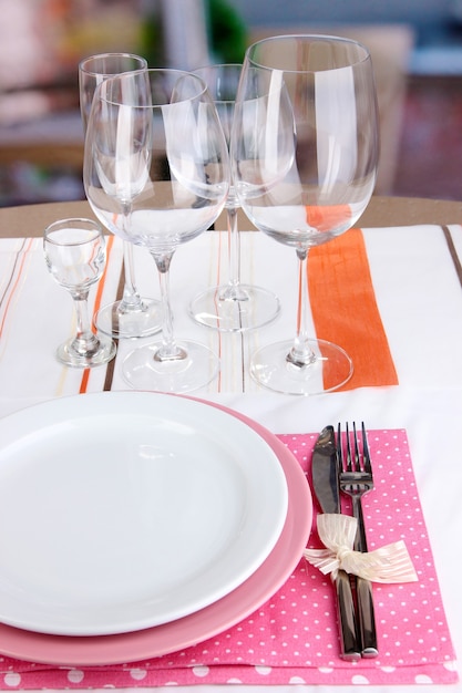 Configuração de mesa com copos para bebidas diferentes na mesa no fundo da sala