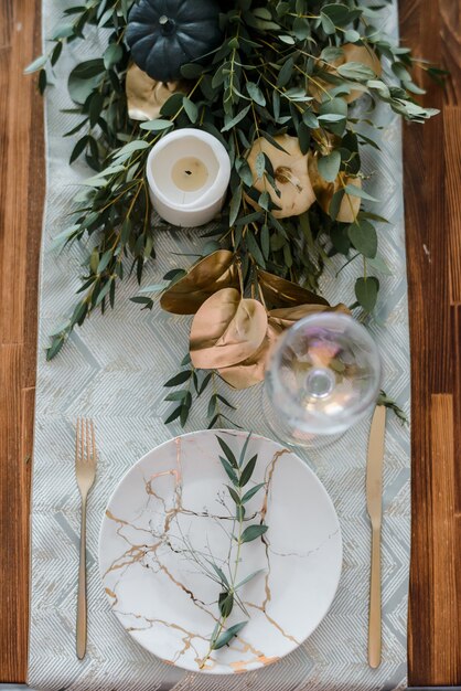 Configuração de mesa de Halloween em fundo escuro. Prato com doces s sobre uma mesa escura com abóbora preta e dourada. Conceito de férias da moda de vista superior plana leigos.