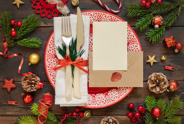 Configuração de mesa festiva com decorações de Natal, cartão em branco de galhos de árvores de abeto e envelope selado