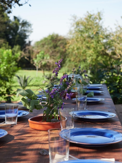 Configuração de mesa para festa de banquete com pratos vazios e copos no parque