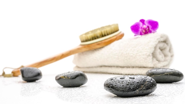 Configuração de spa com escova de pedras de massagem e uma toalha