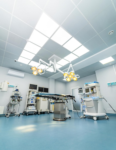 Configuração moderna de sala de cirurgia com luzes cirúrgicas Uma sala de cirurgia bem equipada com luzes cerúrgicas avançadas, monitores e equipamentos médicos prontos para o procedimento