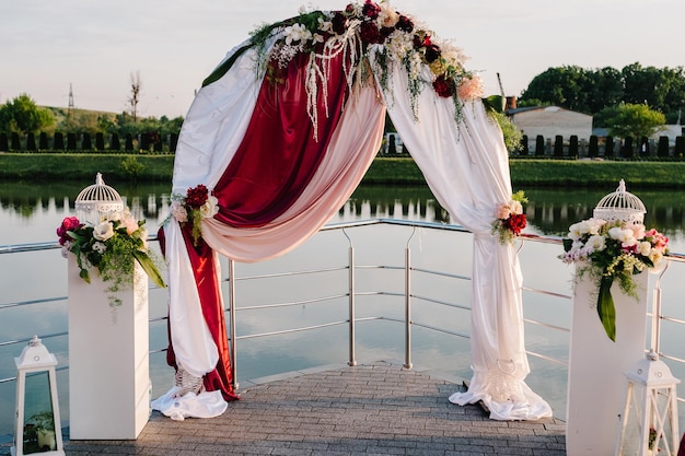 Configuración de la ceremonia de boda en el muelle Arco de boda decorado con flores Ambiente de boda paisaje celebración Concepto de fotografía