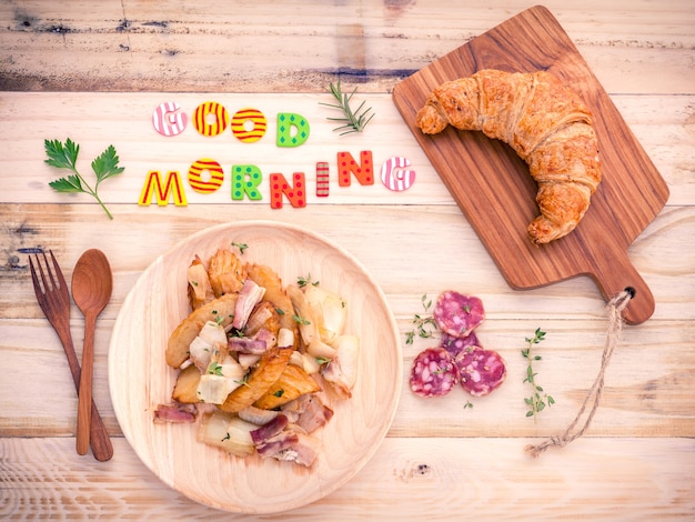 Configuración de desayuno en la mesa de madera con coloridas palabras de Buenos días.