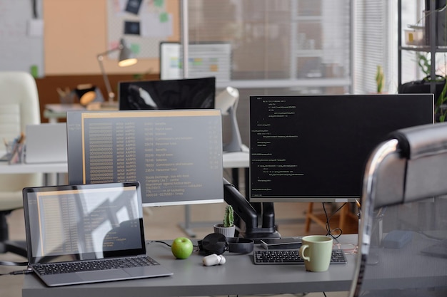 Configuración del escritorio de programación de oficina con computadora y portátil