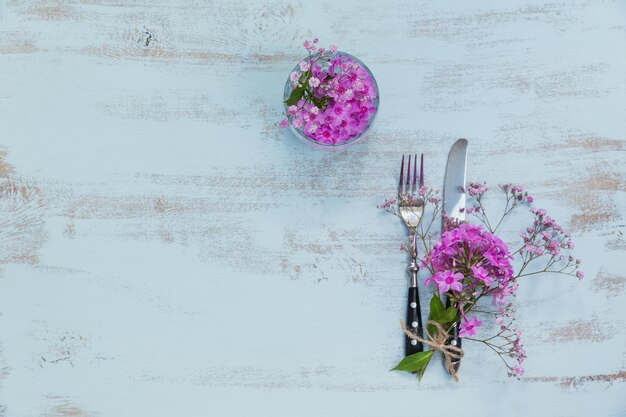 Foto configuración de mesa rústica con flores rosadas en una mesa de madera clara