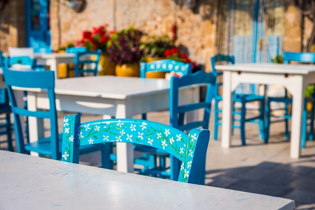 Configuración de mesas y sillas en un restaurante italiano tradicional en Marzamemi - Sicilia durante un día soleado