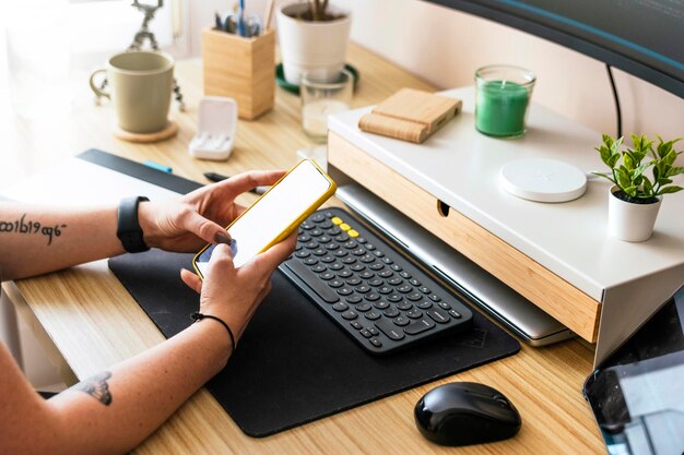 Configuración de trabajo en casa para teletrabajo Mujer joven usando un teléfono para trabajar desde casa