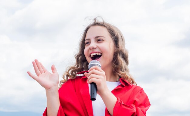 Confira a nova música garota feliz aproveite o momento Divirta-se na celebração criança adolescente cantando com microfone no karaokê criança cantando cantor ao ar livre com microfone infância feliz