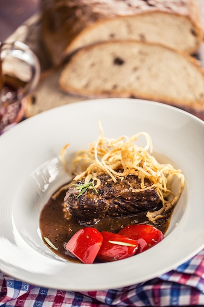 Confit Rindersteak mit Soße gebratenem Zwiebelbrot Fassbier und Dekoration im Pub oder Restaurant.