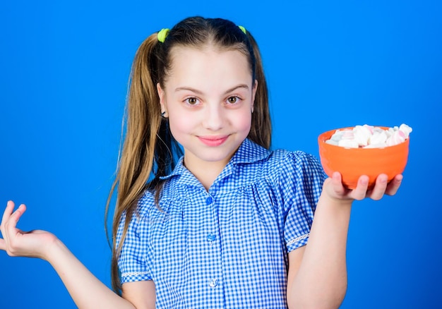 Confitería feliz niño pequeño amor dulces y golosinas Niña pequeña come malvavisco malvavisco Tienda de dulces Alimentos saludables y cuidado dental Dieta y calorías Concepto de confitería golosa