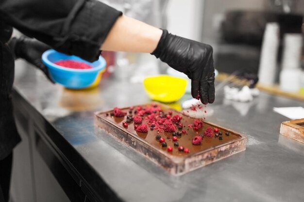 Foto el confitero hace postre de chocolate en la tienda de dulces