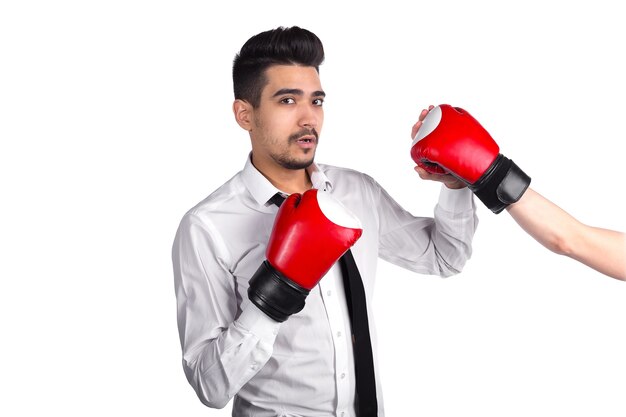 Conflicto empresarial, protección contra el concepto de competencia. Joven empresario en guantes de boxeo peleas con competidor, fondo blanco.