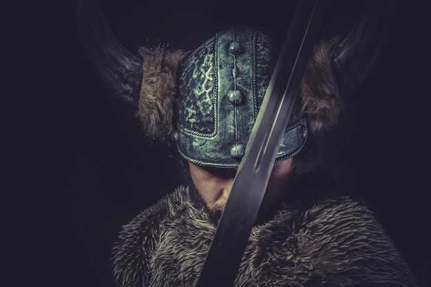 Conflito, guerreiro viking com uma enorme espada e capacete com chifres