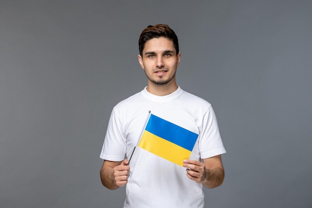 Conflito russo ucraniano corajoso bonitão bonito de camisa branca segurando bandeira ucraniana