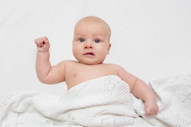 Confundido fruncir el ceño cara de bebé infantil divertido que pone debajo de la manta con la mano