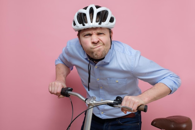 Confundido hombre caucásico vistiendo en bicicleta sobre fondo de colores