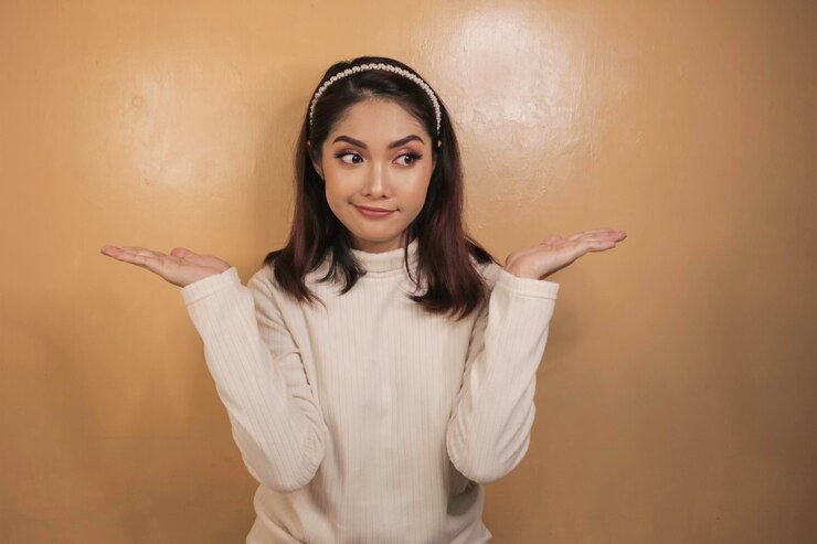 Foto confundir el gesto de una hermosa chica asiática con una camisa blanca
