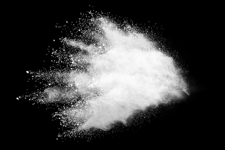 Foto congelar el movimiento de las explosiones de polvo blanco aisladas sobre fondo negro.