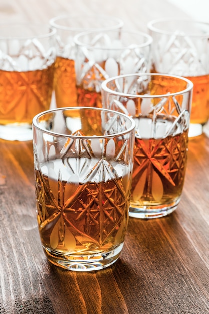 Conhaque em copos de vinho de cristal em uma mesa de madeira