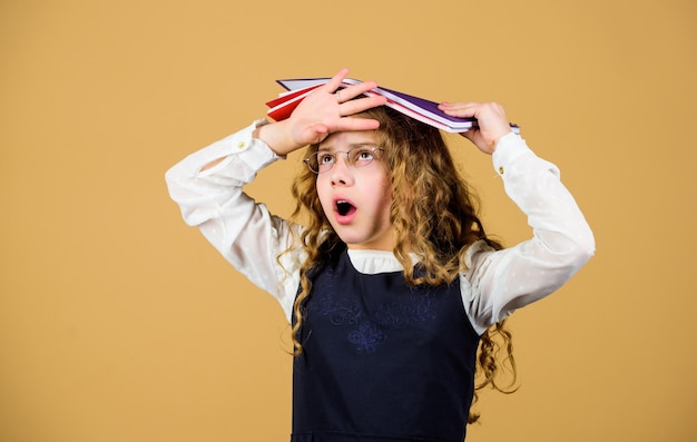 Conhecimento e educação De volta às aulas caderno de lição de casa para notas do diário lição de estudo menina pequena com pasta de papel menina cansada quer ser professora Estudando muito