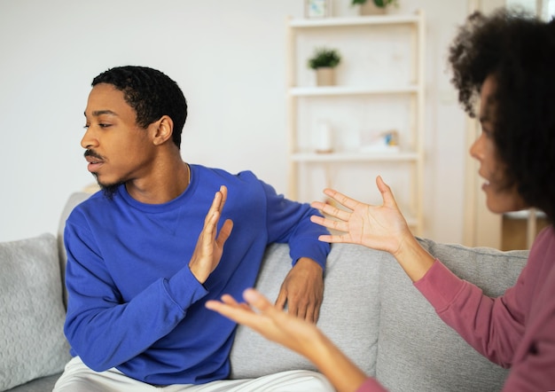 Cônjuges africanos com conflitos comunicando seus sentimentos no lar moderno