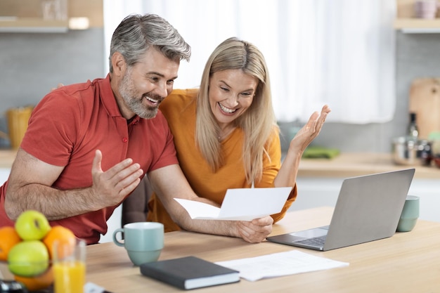 Cônjuges emocionais lendo carta do banco comemorando o sucesso