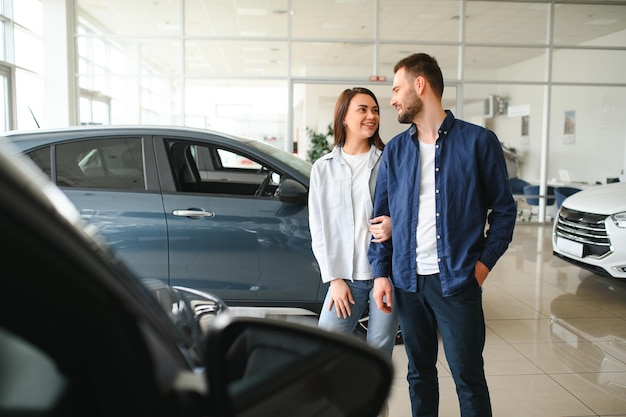 Cônjuges entusiasmados dançando no escritório da concessionária depois de comprar um carro novo