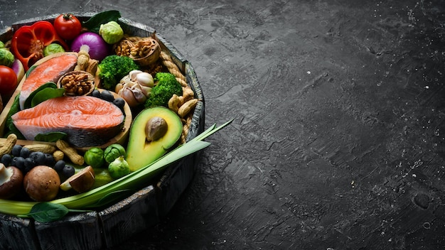 Conjunto de alimentos saludables en una caja Sobre un fondo de piedra negra Vista lateral Espacio de copia