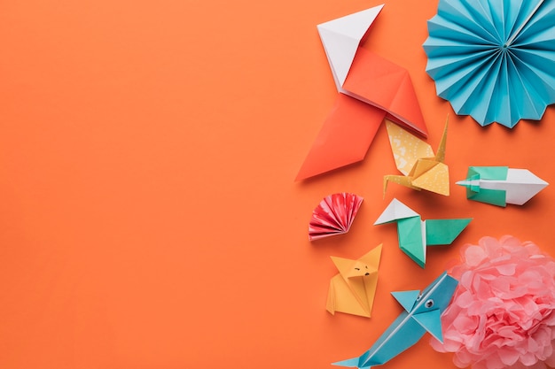 Foto conjunto de arte de papel origami arte en superficie naranja brillante