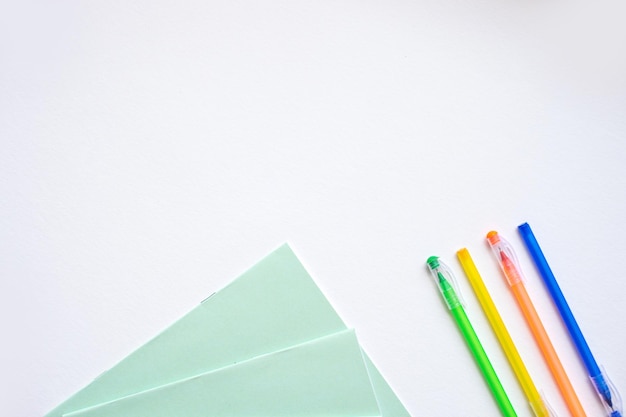 Un conjunto de artículos de papelería sobre un fondo blanco bolígrafos de diferentes colores.