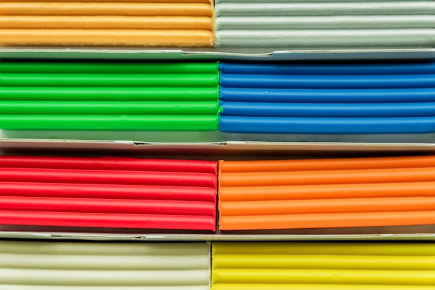 Conjunto de barras de plastilina multicolores para modelar en mesa de madera. Vista superior, educación y concepto de creatividad.