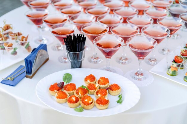 Conjunto de bocadillos fríos caviar rojo en cestas En el fondo bebidas en hermosos vasos Buen verano
