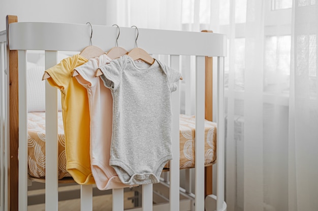 Conjunto de body de bebé para niña o niño recién nacido en la cama infantil. Habitación del bebé.