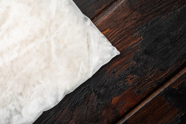 Conjunto de bolsas de arroz en porciones, sobre fondo de mesa de madera oscura antigua, vista superior plana, con espacio para copiar texto