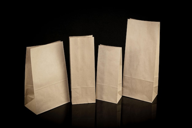 Conjunto de bolsas de papel para ir de compras sobre fondo negro Mockup para diseño