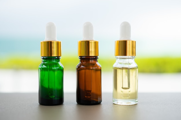 Conjunto de botellas de vidrio multicolor con gotero sobre la mesa. Concepto de aceite aromático, cosmética y belleza de la piel.