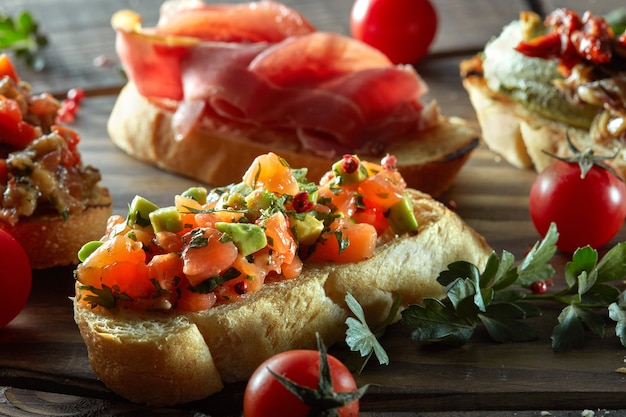 Conjunto de bruschetta. Mesa de madera negra, vista superior, composición horizontal