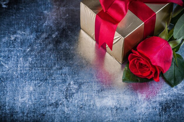 Conjunto de caja de regalo de rosa roja sobre fondo metálico rayado