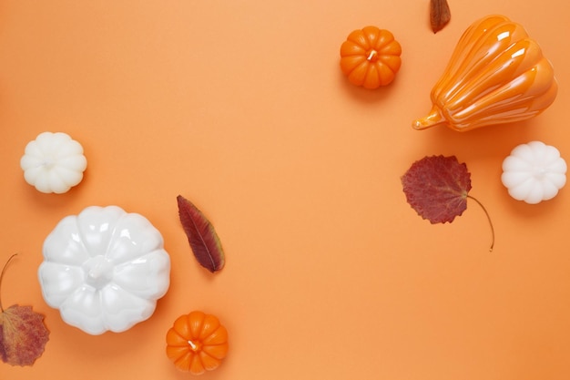 Conjunto de calabazas de cerámica y velas sobre fondo naranja Decoración de interiores de decoración de otoño