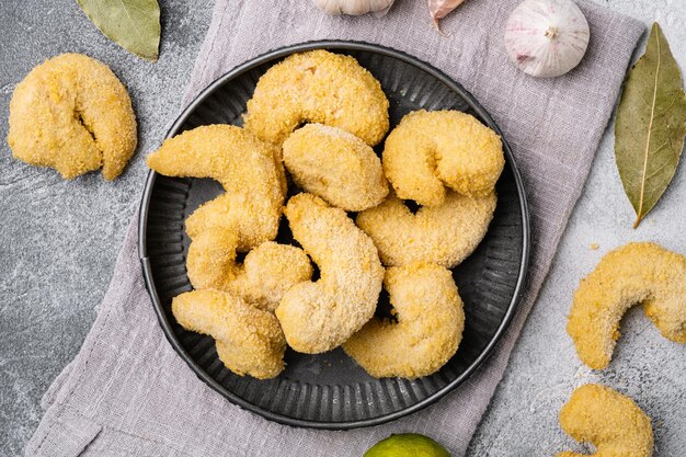 Conjunto de camarones fritos empanizados, sobre fondo de tabla de piedra gris