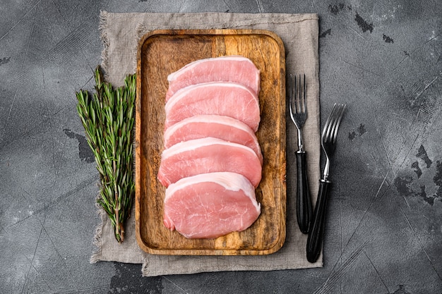 Foto conjunto de carne de cerdo fresca, sobre fondo de mesa de piedra gris, vista superior plana, con espacio para copiar texto