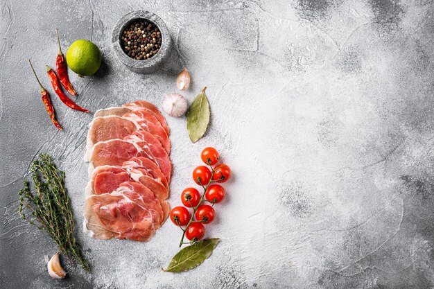 Conjunto de carne italiana curada en frío, sobre fondo de mesa de piedra gris, vista superior plana, con espacio para copiar texto