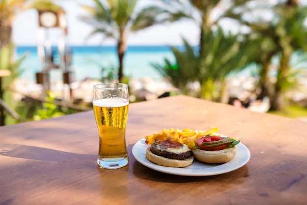 Conjunto de cerveza de hamburguesa y papas fritas Un conjunto estándar de bebidas y comida en el pub Cerveza y bocadillos Comida rápida de fondo oscuro Comida americana tradicional